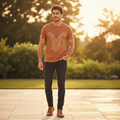 Man wearing terracotta Rare Rabbit geometric tee on sunlit terrace at golden hour