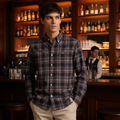 Man wearing dark charcoal plaid shirt in upscale lounge