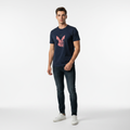 Man wearing navy blue Rare Rabbit tee in minimalist studio with dramatic lighting