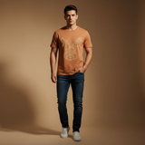 Man wearing terracotta Rare Rabbit geometric tee against warm beige studio backdrop
