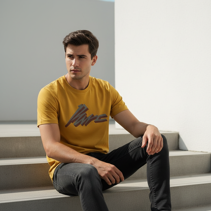 Man wearing mustard yellow HD print tee sitting on steps in minimalist outdoor space