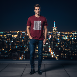 Man wearing maroon Rare Rabbit crystal R tee on rooftop at night with city lights bokeh