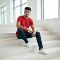 Man wearing red Together Rare Rabbit tee sitting on minimalist steps